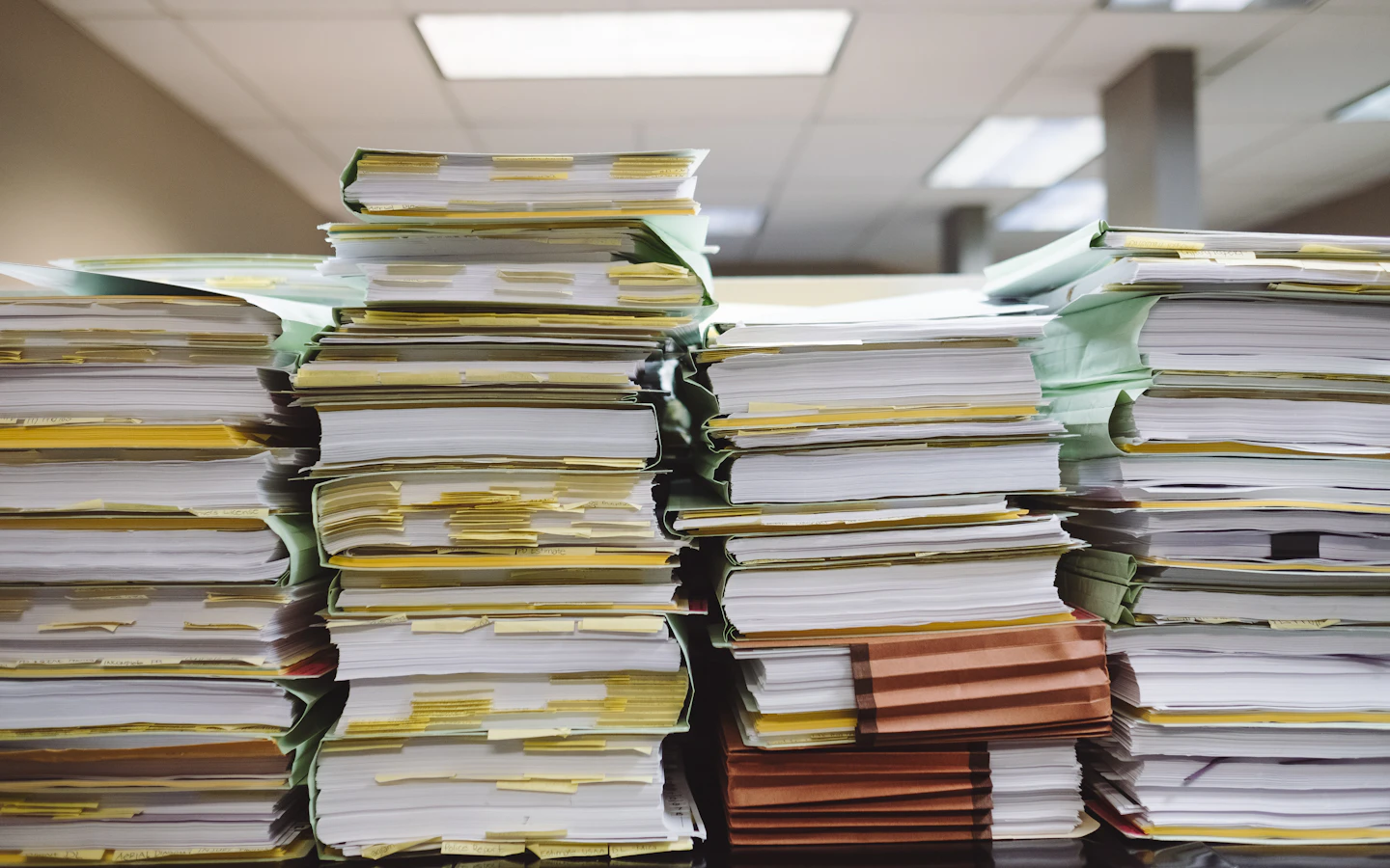 Pilas de expedientes y fólders acumulados en una oficina